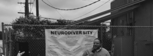 Neurodiversity Day's Speaker stands in front of poster explaining neurodiversity.